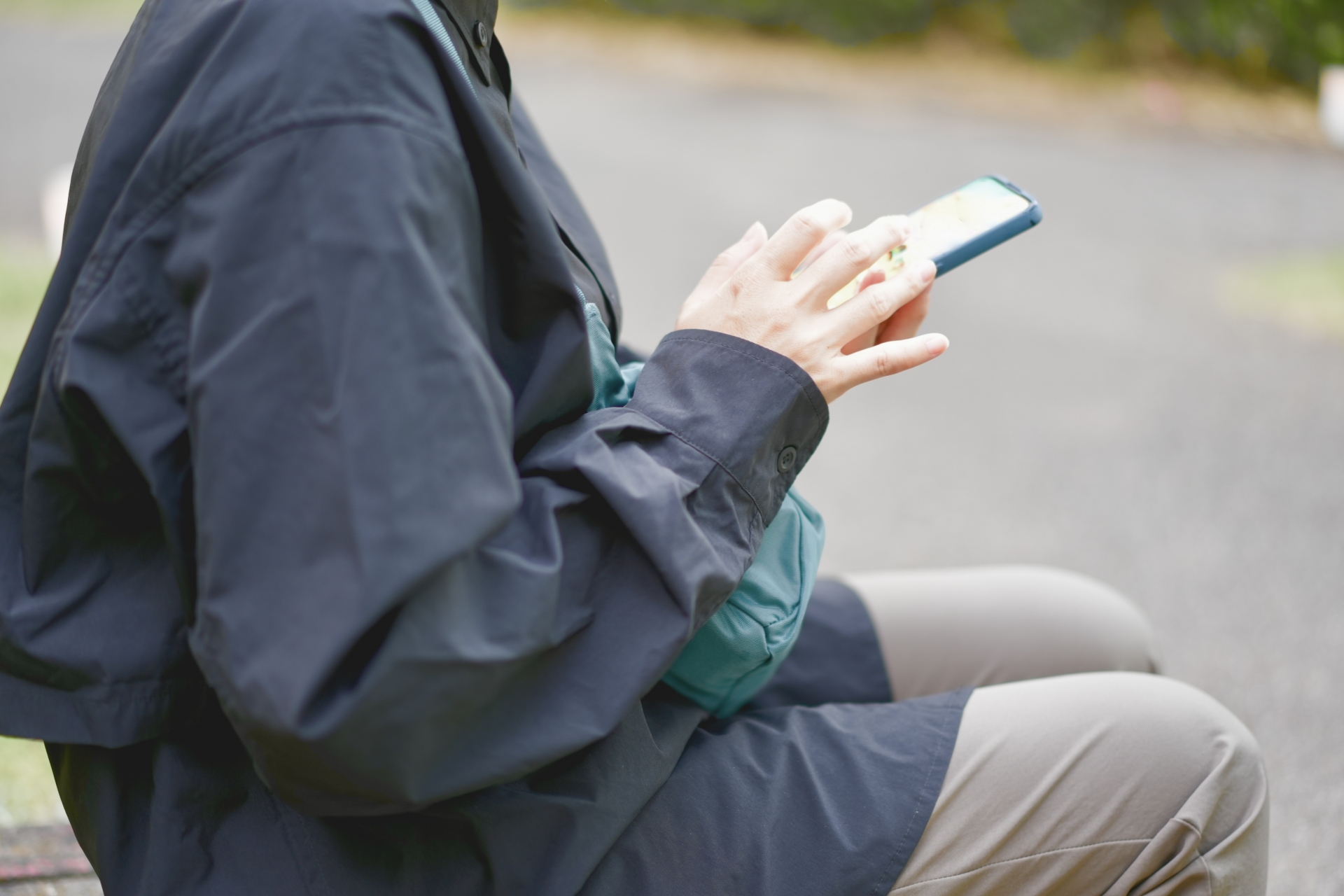 ベンチに座ってスマホを操作する人