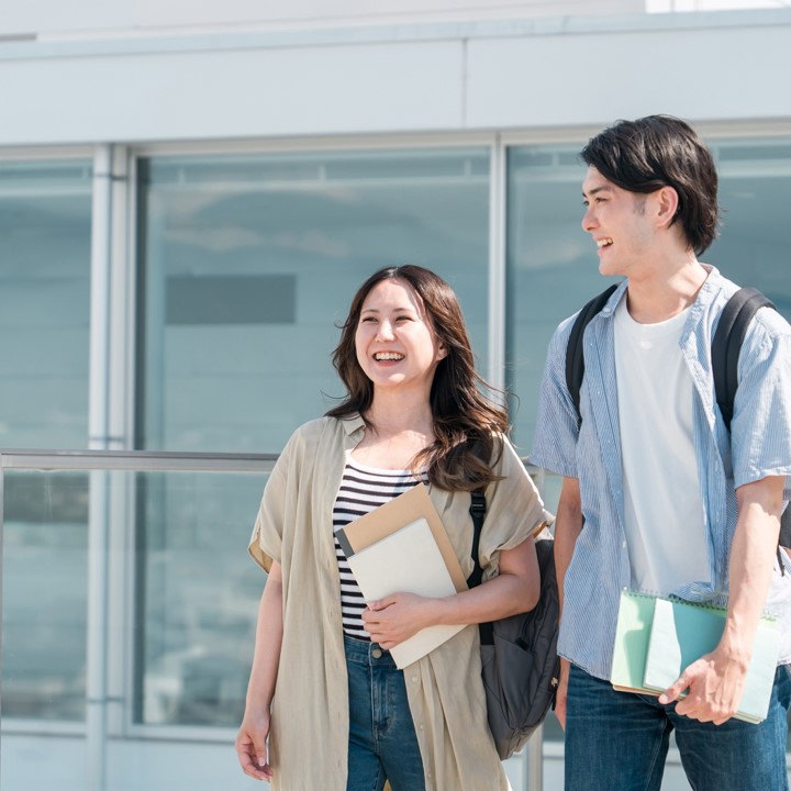 天気の良い屋外を笑顔で歩く男女