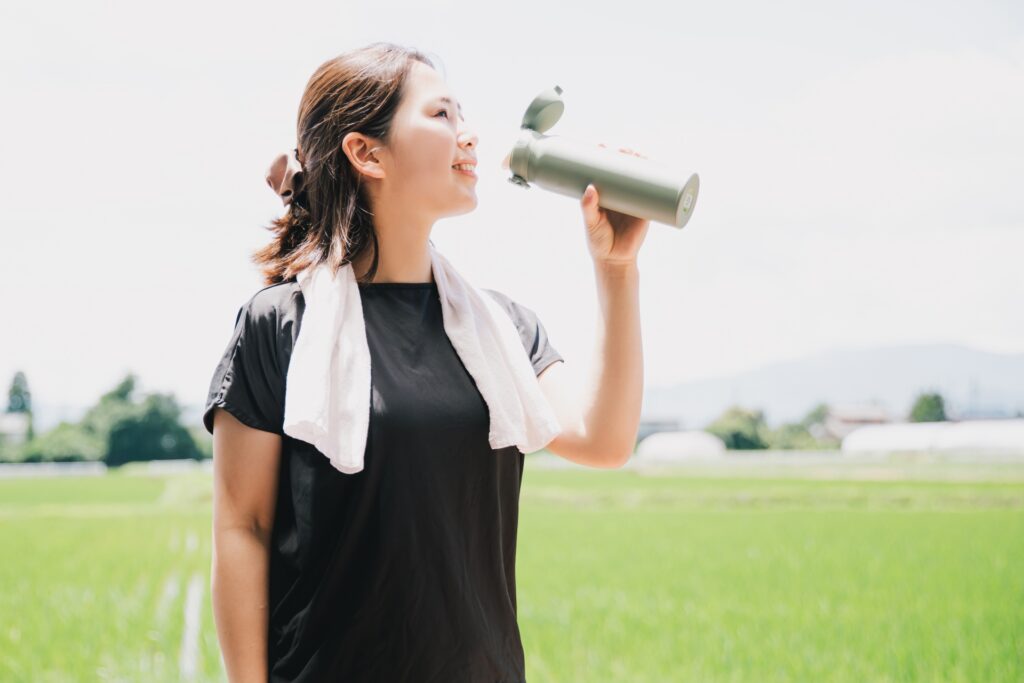 水筒で水を飲む黒いTシャツの女性