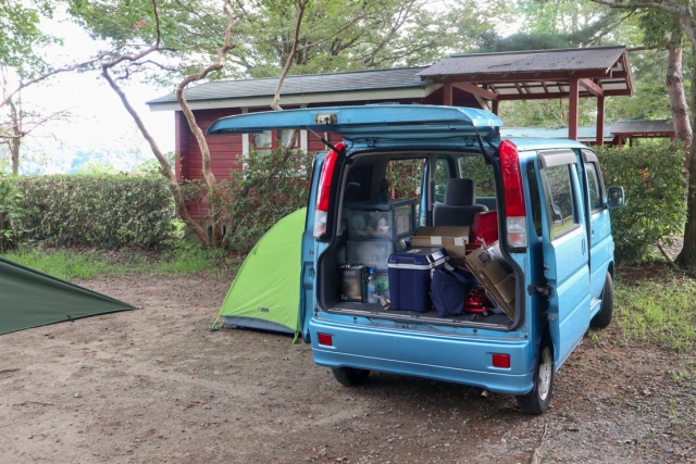 水色の軽自動車と緑色の小さなテント