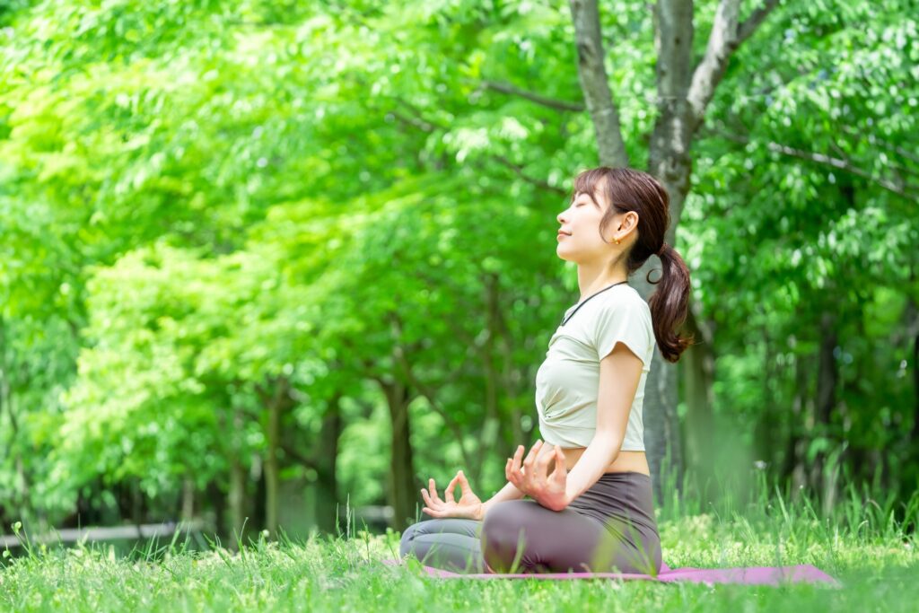 公園で座って瞑想する女性