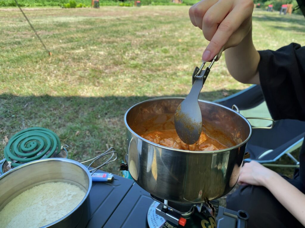 キャンプでカレーを作っている手