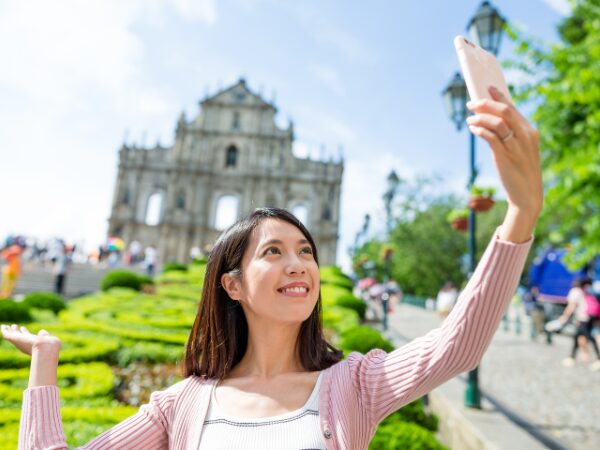 パーク内でスマホ片手に自撮りをしている若い女性