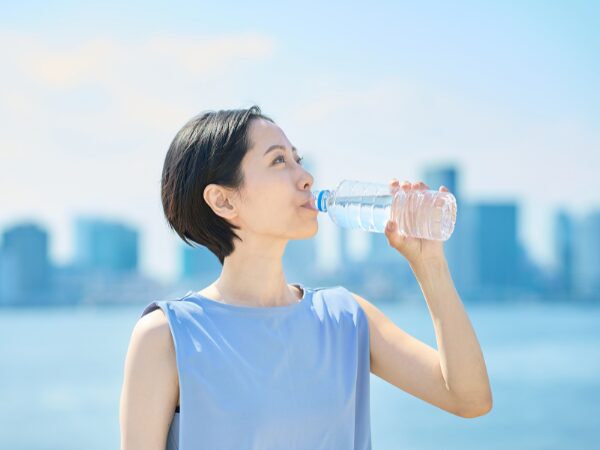 ペットボトルの水を飲んでいるショートヘアーの女性