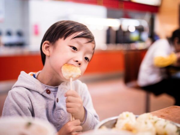 フードコートでパンを食べる子ども
