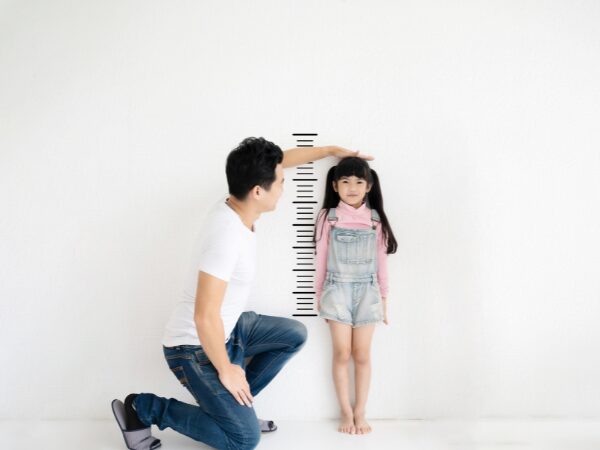 子どもの身長を計る父親