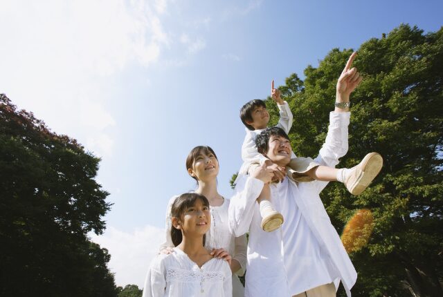 肩車して指をさす四人家族