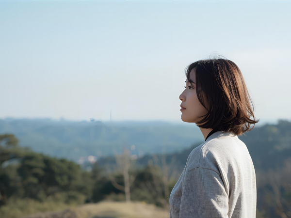 景色の良い場所で遠くを見ている女性