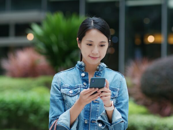 屋外でスマホで検索している女性