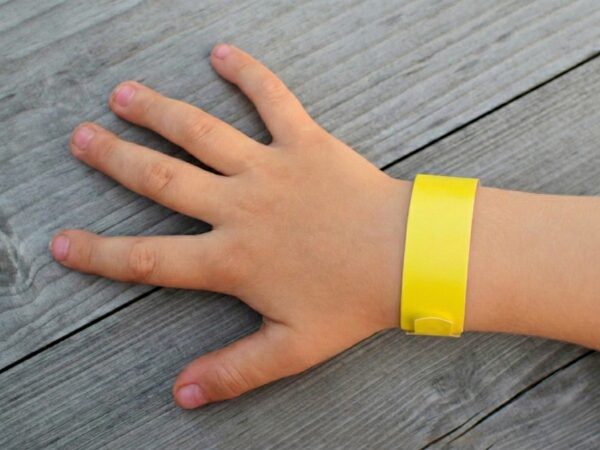 子どもの右手首に巻いた黄色い紙製のリストバンド